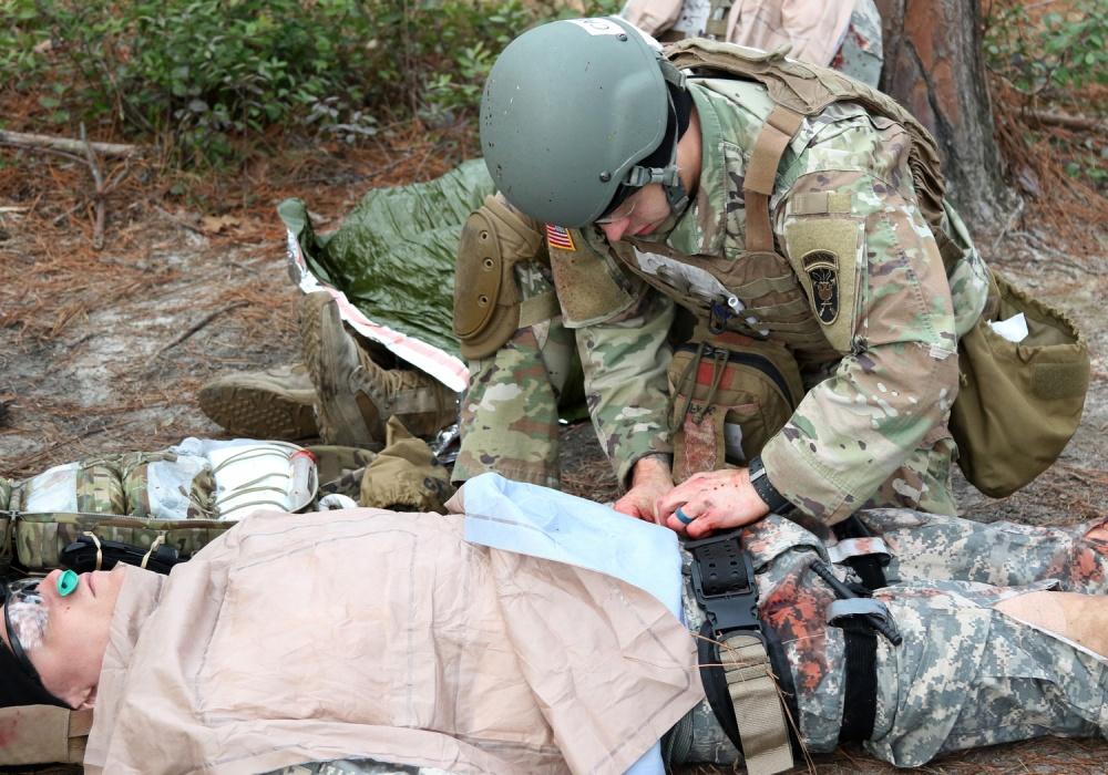 Army medic works on simulated patient to perform GSW triage
