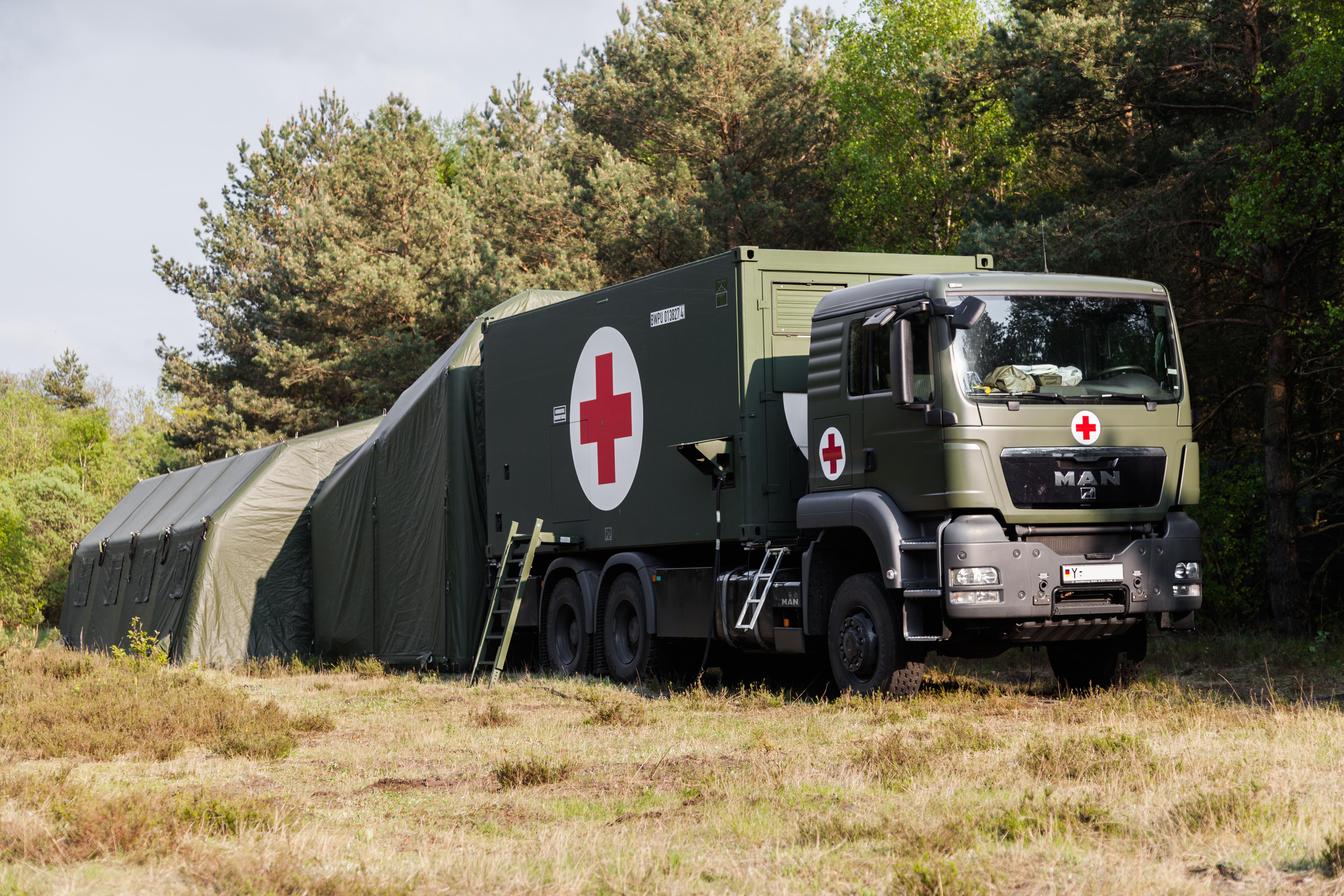 Medical transport vehicle with red cross on side