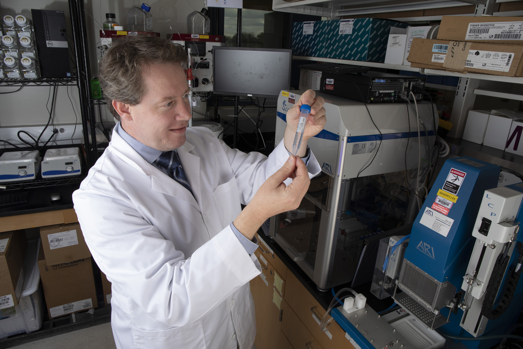 Man in lab coat with pipette