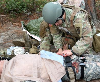 Army medic works on simulated patient to perform GSW triage