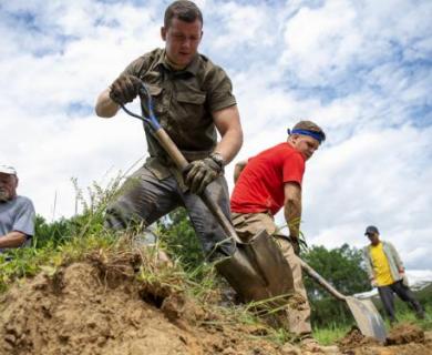 Men shovel dirt looking for U.S. military remains.