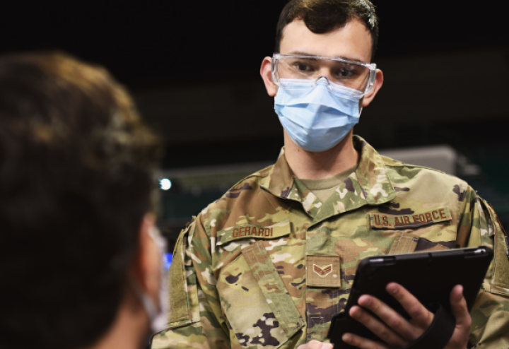 Man in US Air Force uniform stands with tablet in his hand