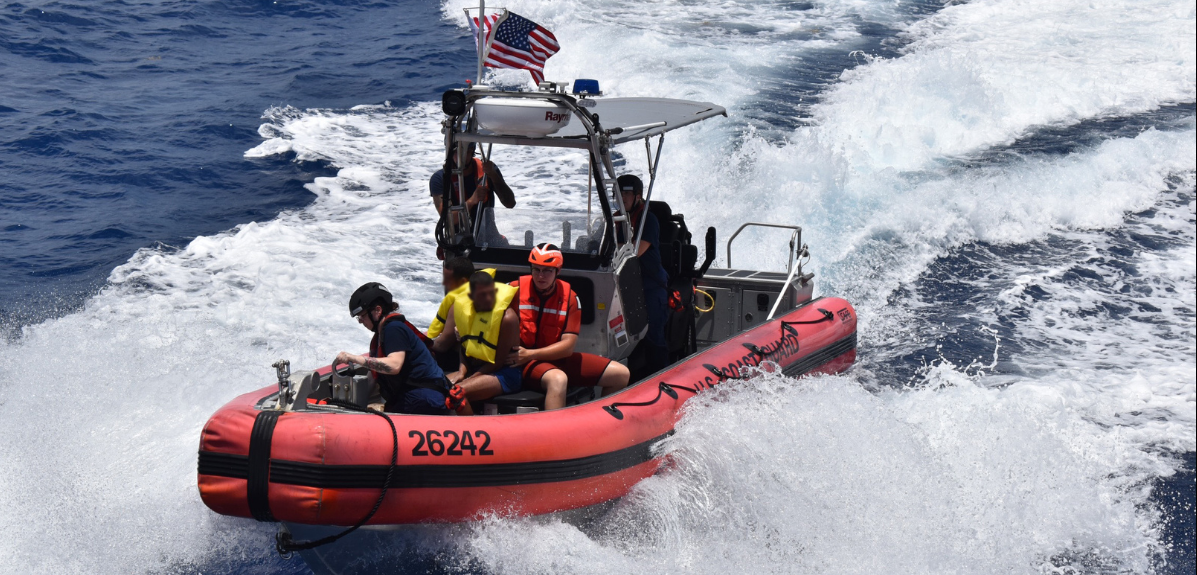 Five people ride a Coast Guard boat