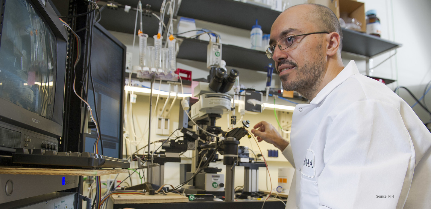Scientist works with microscope and computer 