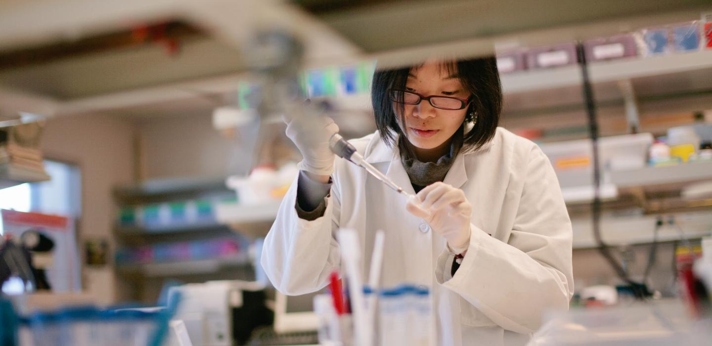 Female scientist works with pipette and culture